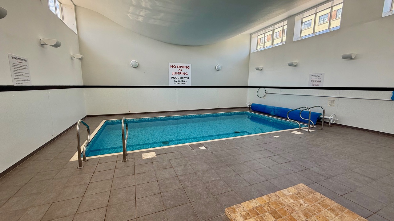 “Private swimming pool at Hayes Point with calm water and surrounding patio area.