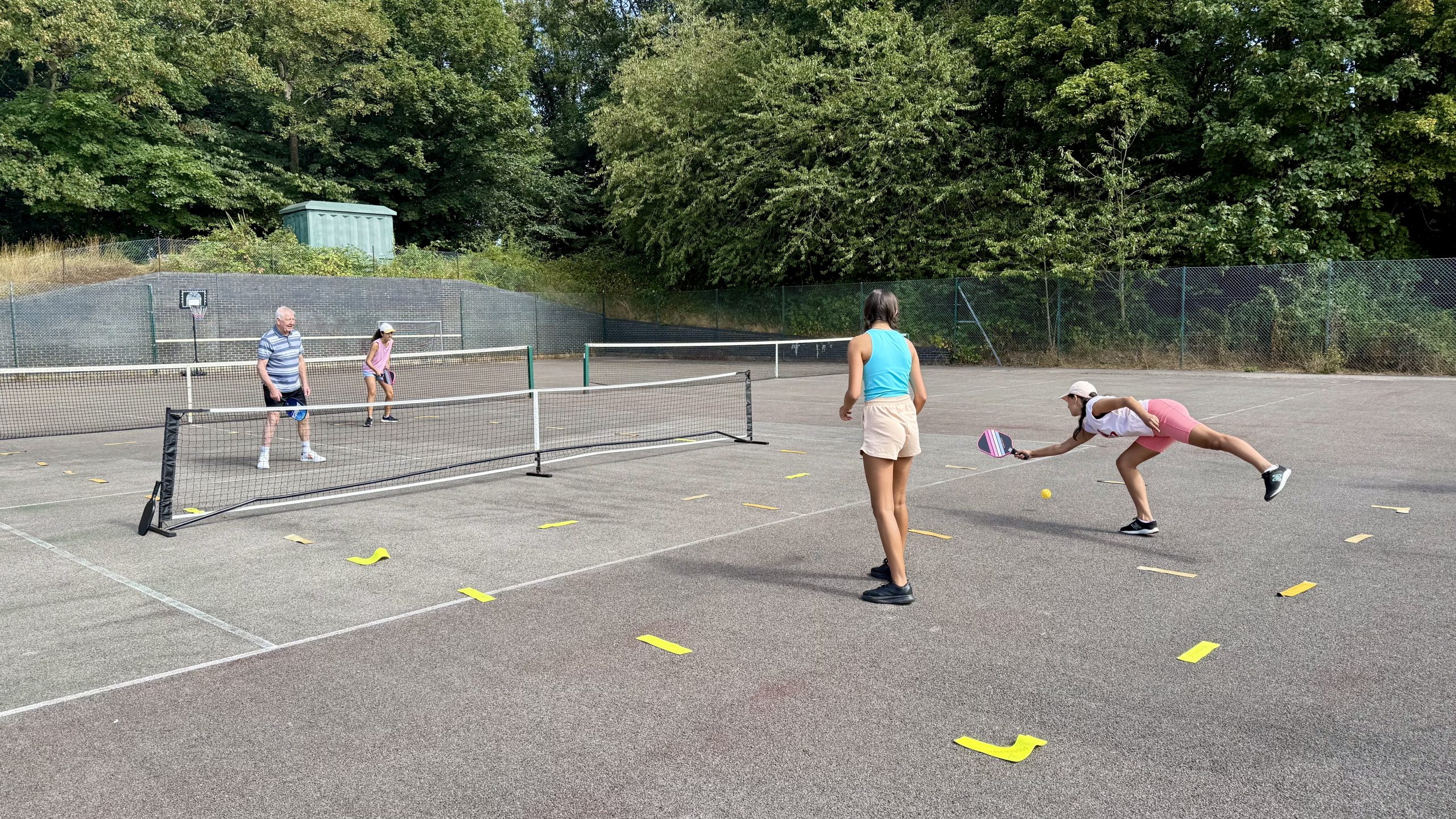 Hayes Point outdoor pickleball court surrounded by trees and greenery, with game in play.